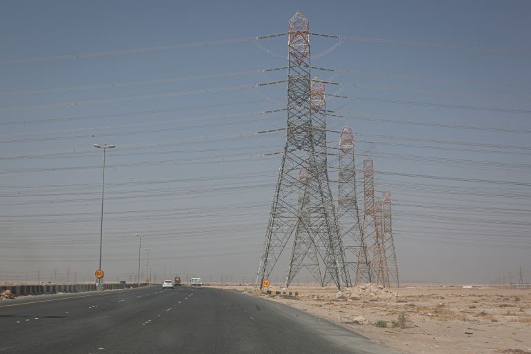 ABDALI, KUWAIT - OCTOBER 7, 2023: Overhead power lines transmit electrical energy across Kuwait. The Gulf emirate relies entirely on burning fossil fuels for electricity generation.