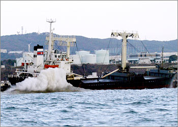 Waves break over the North Korean freighter Chil Song after it ran aground on a breakwater on Thursday near the Hitachi port, 80 miles (130 km) northeast of Tokyo December 6, 2002. Japanese coast guard vessels were on the scene, trying to contain and remove the oil spilled by the 3,144 tonne ship, which was carrying 1,200 tonnes of chipped tyres. None of the 21 North Korean crew members were injured and they remained on board the ship, according to officials. REUTERS/Issei Kato