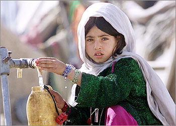An Afghan girl collects water near a refugee camp at the Chaman border crossing March 12, 2003. Security has been tightened along the Pakistan-Afghan border to stop the infiltration of al Qaeda members into Pakistan. REUTERS/Faisal Mahmood