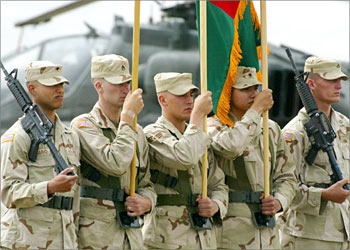 U.S. soldiers hold American and Afghan flags during a ceremony transferring command from U.S. Army Lt. General Dan McNeil to Army Major General John Vines at Bagram airbase north of Kabul, May 27, 2003. About 11,500 coalition troops are based in various parts of Afghanistan in pursuit of members of the Taliban and its al Qaeda allies. REUTERS/Kamal Kishore