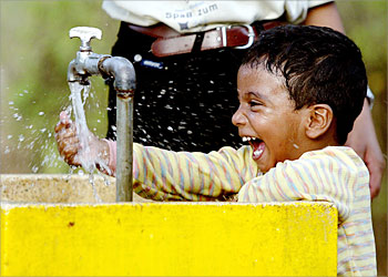 R_A young boy splashes water on his face to escape the 47 degrees Celsius (116 degrees Fahrenheit) heat in Hyderabad, capital of the south Indian Andhra Pradesh state, June 1, 2003. The severe heat wave in southern India which has claimed more than 500 lives in the last two weeks. REUTERS/Sherwin Crasto