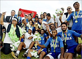 The Raja Casablanca celebrates 23 November 2003 as they pose with the trophy after winning the second leg of the CAF final against Cotonsport Garoua in Garoua. Raja Casablanca of Morocco forced a 0-0 draw with Cotonsport Garoua of Cameroon today to win the last edition of the CAF Cup. The 'Green Devils' led 2-0 from the first leg in Casablanca two weeks ago and several heroic saves from experienced goalkeeper Mustapha Chadili ensured they retained their advantage. AFP PHOTO DESIREY MINKOH
