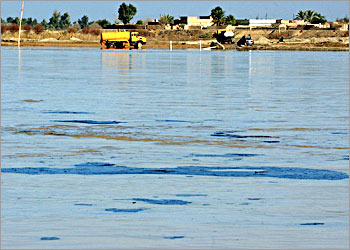Iraqi water tankers collect water from the Tigris river as large black plates of oil flow on the muddy water of the river in Tikrit, some 180 kilometers (110 miles) north of Baghdad, 30 January 2004. Oil engineers were plugging a leak in a pipeline in northern Iraq which is polluting the river, one of the countrys main sources of water, according to a military spokeswoman. Experts have warned that further damage to the countrys two main rivers, Tigris and Euphrates, could pose a serious health treat and spell the end of the Mesopotamian marshes, one of the countrys environmental landmarks. AFP PHOTO/Jewel SAMAD