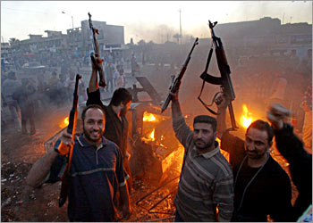 Muslim Shiite members of Shiite radical leader Moqtada al-Sadr Army of Mehdi militia celebrate near a burning US Humvee in Baghdads al-Sadr City district late 04 April 2004. The radical cleric , whose militiamen are clashing with US-led coalition troops in Iraq, told his supporters to terrorize the enemy as demonstrations were no longer any use. Clashes today with coalition troops have left some 25 dead Iraqis and hundreds of injured. AFP PHOTO/AHMAD AL-RUBAYE