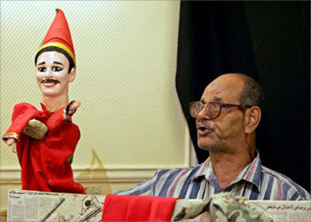 TO GO WITH AFP ARABIC STORY: "EGYPT-CULTURE-THEATRE-ARAGOZ" Egyptian puppeteer Mustafa Othman, known as Am Saber (Uncle Saber) performs with his Aragoz puppet at the Egyptian National Theater in Cairo 16 August 2004. Othman, 65, is the only puppeteer left working in Egypt. The Aragoz, which was introduced in Egypt in the 13th century and was popular in traditional and religious festivals, is facing the danger of extinction. AFP PHOTO/Marwan NAAMANI