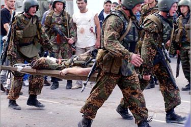 Russian special forces soldiers carry an injured colleague during the rescue operation of Beslan's school, northern