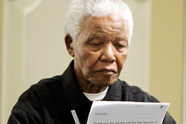 REUTERS - South Africa's former President Nelson Mandela holds his speech notes after making an address at the launch of the