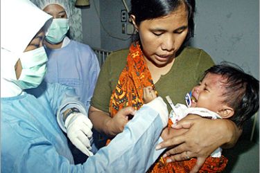 REUTERS/ An Indonesian nurse checks the temperature of Silvi, a 20-month-old polio patient, at the Sulianti Saroso hospital in Jakarta May 14, 2005. Indonesia has detected two new polio