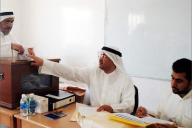 A Kuwaiti man casts his vote at a polling station during the municipal council elections in Kuwait City 02 June 2005.