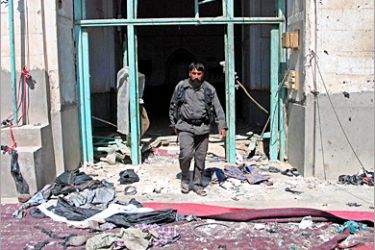 REUTERS/ An Afghan policeman walks out of a mosque after a suicide bomb attack in the southern city of Kandahar June 1, 2005. The police chief of Afghanistan's capital Kabul, Akram