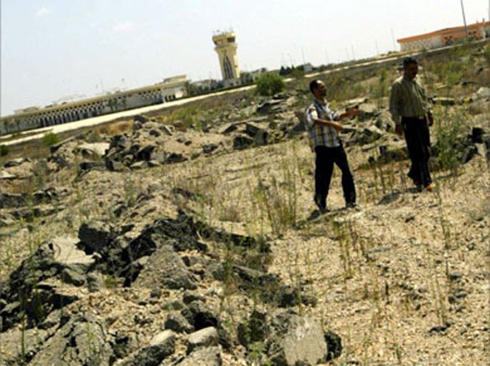 Palestinian engineers walk on the destroyed runway of the international airport in southern Gaza, near the town of Rafah on the Egyptian border, 26 August 2005