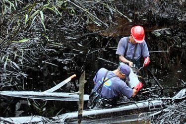 f_Employees of Ecuador's Petroecuador oil company work on clean up operations after an oil spillage