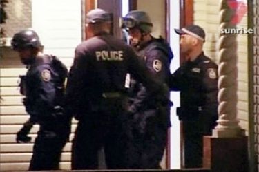 A video grab shows police walking outside a house during a raid in Sydney November 8, 2005. Australian authorities believe they have foiled a major terrorist attack, arresting 17 people during raids in the country's two biggest cities of Sydney and Melbourne. One man was shot in the Sydney raids and the police bomb squad was examining a backpack at the scene.