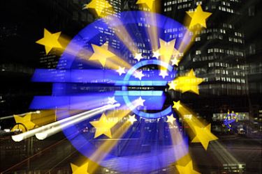 r_The illuminated euro sign at the European Central Bank's (ECB) headquarter is photographed