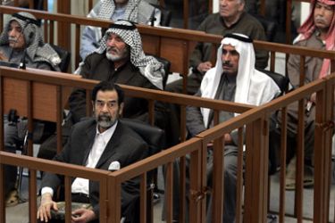 Defendants in first row of cage, left to right, Saddam Hussein; second row of cages, left to right, Taha Yassin Ramadan, Abdullah Kadhem Ruaid, Mizher Abdullah Rawed; third row of cages, left to right, Mohammed Azawi Ali, Ali Dayim Ali, Barzan Ibrahim al-Tikriti appear at their trial held under tight security in Baghdad’s heavily fortified Green Zone, 05 December, 2005.