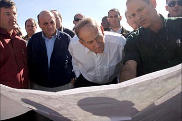 f_Interim Israeli Prime Minister Ehud Olmert (C), Israeli Defense Minister Shaul Mofaz (L) and local officials review a map of the West Bank Jewish settlement block of Gush Etzion during a tour of the area February 7, 2006. ISRAEL OUT REUTERS/GPO/Avi Ohayon/Handout