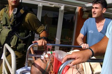 A wounded Israeli soldier is carried into a hospital in the southern Israeli town of Beer Sheva June 25, 2006. Palestinian militants launched on Sunday their first deadly raid into Israel from Gaza since an Israeli pullout last year, killing at least two Israelis in an assault in which several of the attackers also died.