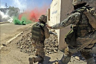 f_An image released by the US Army 17 June 2006 shows a US soldier tapping a marine on the shoulder to continue bounding across a smoke filled intersection notorious for sniper fire while on patrol in the Iraqi restive city of Ramadi, west of Baghdad, 06 June 2006.