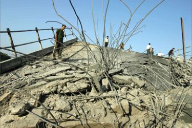 Palestinian man walks over the debris of a destroyed bridge following an overnight Israeli air strike on the western entrance of Gaza City, 28 June 2006