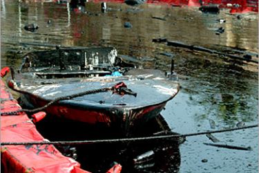AFP / A small speed boat sits among a thick layer of oil covering the water at a small port at the ancient city of Byblos, east of Beirut, 19 August 2006. At 15,000 tons of leaked oil from the