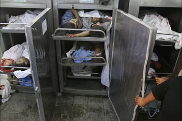 f_A morgue worker is seen as bodies are piled into the morgue fridge at the Beit Lahia hospital in the northern Gaza Strip 08 November 2006, following an Israeli military