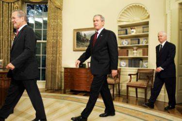US President George W. Bush (C) winks while walking into the Oval Office of the White House in Washington, DC, with outgoing Defense Secretary Donald Rumsfeld (L)