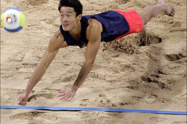 f_China's Li Jian dives to receive the ball during their Asian Games men's beach volleyball gold medal match in Doha, 11 December 2006. Zhou Shun and Li Jian pair beat Wu Penggen and Xu Linyin pair by 2-1 (22-20, 12-21, 15-13) to got the gold medal. AFP PHOTO / TOSHIFUMI KITAMURA