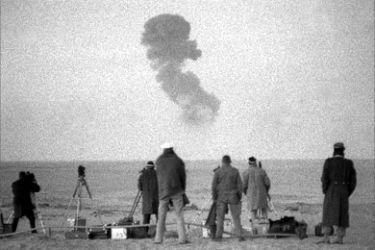 This file picture taken in the 1960s near Raggane in the Algerian Sahara shows officials watching a French nuclear test.