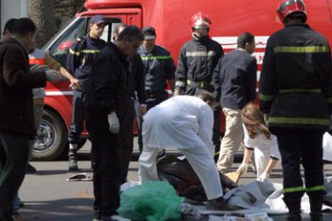 Paramedics remove pieces of the dismembered body of a suicide bomber into a cardboard outside the US cultural center in Casablanca, 14 April 2007, after two suicide