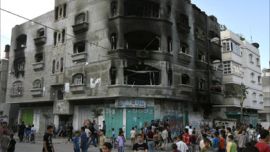 Palestinians gather in front of a burnt building housing the apartment of Jamal Abu al-Jadian, a head for northern Gaza of Al-Aqsa Martyrs Brigades, loosely affiliated to Fatah in Beit Lahia, northern Gaza Strip, 12 June 2007