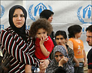 لاجئة عراقية وأطفالها أمام مقر المفوضية العليا للاجئين في العاصمة السورية (الفرنسية-أرشيف)