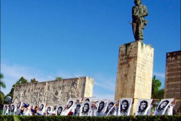 afp : Cuban students hold banners with the image of revolutionary leader Ernesto 'Che' Guevara during the official ceremony to commemorate the 40th anniversary of his death