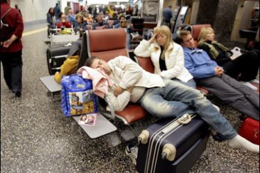 r/Passengers await their flight at Malpensa airport in Milan October 22, 2007