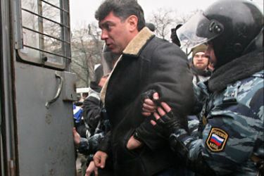 f_Russian riot policeman detain Boris Nemtsov, leader of the opposition SPS party and presidential hopeful for the presidential elections, during a rally organized by opposition