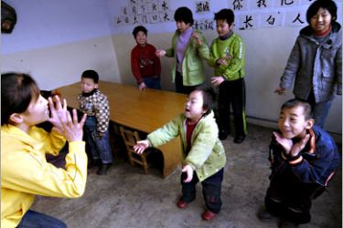 REUTERS/ Mentally handicapped children play games with their teacher at a special school in Lucheng, Shanxi province, November 30, 2007. A 2006 national survey showed that China has nearly 82.96 million disabled people, among those about 3.87 million are aged under 14, Xinhua News Agency said. Picture taken November 30, 2007. REUTERS/Stringer (CHINA)