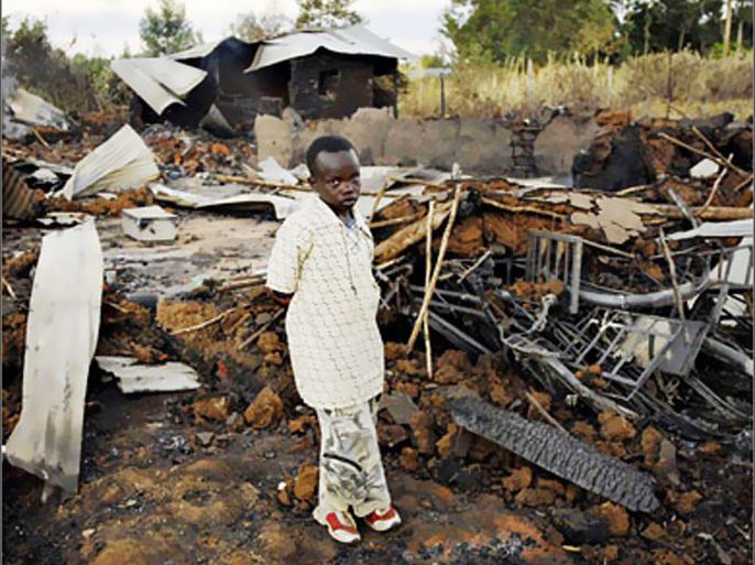 REUTERS/An 11-year-old survivor stands amid the burnt out ruins of the Kenya Assemblies of God Pentacostal church, where at least 18 people were bruned