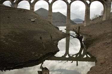 r_An old bridge is reflected on a pool of water at the Barrios de Luna reservoir in the northern Spanish province of Leon February 14, 2008. Spain is facing one of its worst