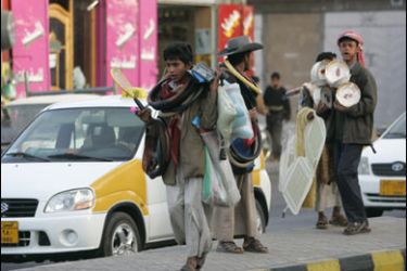 REUTERS/Boys sell car and home accessories on a street in Sanaa February 25, 2008.