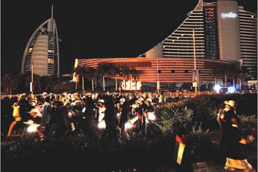 AFPEmirati boys carrying lanterns as they gather outside the Al-Jumeirah (R) and the Burj Al-Arab Hotels that have dimmed the external lights to mark