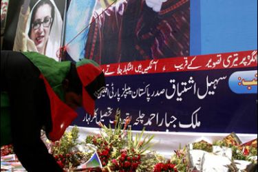 REUTERS/A supporter of slain opposition leader Benazir Bhutto lights candles in front of her picture during a gathering to celebrate her life in Rawalpindi June 21, 2008.