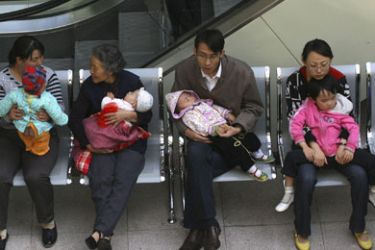 People wait with their children, who will be undergoing medical checks for possible kidney stones, at a hospital in Lanzhou, Gansu province