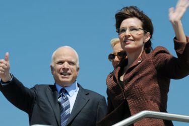Republican presidential candidate John McCain (L) and his wife Cindy (center obscured) and his running mate Alaska Governor Sarah Palin waves as they board the campaign