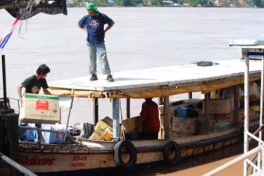 Thai workers load boxes on a boat across the Mekong river at Nong Khai's river port in Nong Khai province near the Thai-Laos border on August 08, 2008. As Asia develops at a