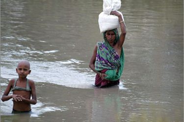 AFP Indian flood-affected people wade through flood water at Raghunathpur area, Madhepura district of India's northeastern state of Bihar
