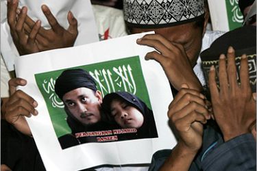 REUTERS/ Supporters of Bali bomber Imam Samudra cry while carrying pictures of Samudra and his daughter during prayers in Serang, Banten province November 9, 2008. Indonesia has