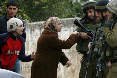 REUTERS / Palestinian women confront Israeli army soldiers while they were carrying out a military operation in the village of Tourah, near the west bank city of Jenin, January 20, 2009.