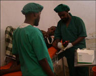 الدكتور علي حسن أحمد (يمين) أثناء عملية صغيرة في غرفة العمليات (الجزيرة نت)