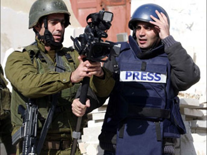 r : An Israeli army officer (C) grabs a camera from Reuters cameraman Yusri al-Jamal as he prevents him from covering news events in the West Bank city of Hebron