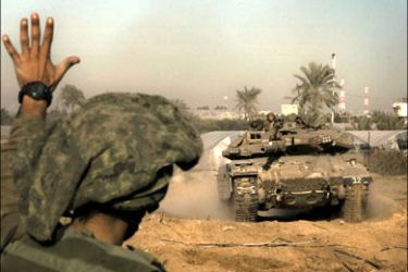 afp : An Israeli soldier signals to a tank to stop as they operate within the northern Gaza strip on January 15, 2009. Israel set Gaza's main city ablaze and killed a senior Hamas