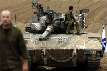 r : An Israeli soldier sits atop a tank (R) at a military staging area outside the northern Gaza Strip January 23, 2009. Israel's invasion of Gaza has strengthened the hand of